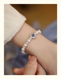 Detailed close-up of pearl bracelet featuring a blue gemstone with micro zircon pavé setting