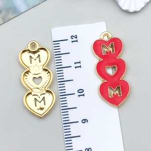 Detailed view of pink enamel heart MOM pendant with measurement ruler for scale