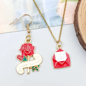 Macro detail of Mother's Day jewelry set with red rose earrings and I Heart U Mom necklace