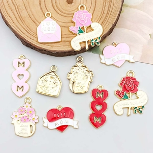 Macro view of Mother's Day pink alloy charms including hearts and flowers with gold trim