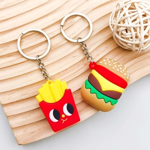 Creatieve PVC-bedeltjes in de vorm van burger en frietjes met gezichtjes op hout