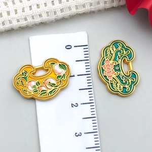 Détail de pendentifs Ruyi en émail jaune et vert avec échelle montrant 2 cm de large