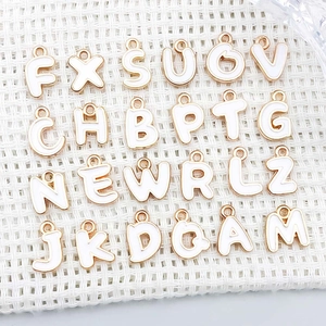 Detailed set of 24 white enamel gold alloy alphabet charms for DIY jewelry making