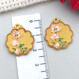 Vue détaillée du pendentif lotus de 2cm avec émail rose et règle de mesure de précision