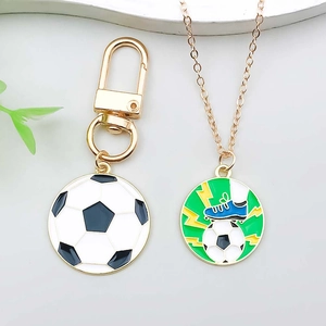 Detail of soccer themed keychains and necklaces with green enamel football and cleats pendants