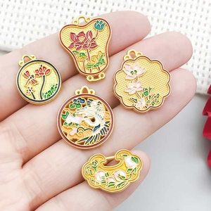 Cinq pendentifs lotus en émail jaune de style chinois traditionnel dans la main
