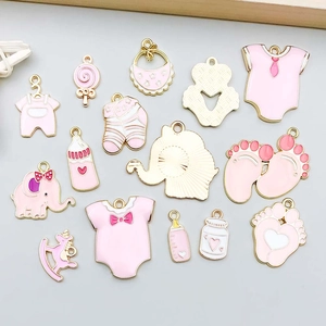 Detalle de dijes esmaltados rosas para bebés con biberones y caballitos de madera