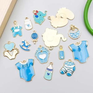 Vista detallada de dijes esmaltados azul bebé biberón y ropa para creación de joyería DIY