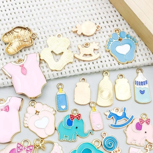 Detalle de dijes esmaltados de bebé como chupete y body para la creación de joyería DIY