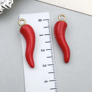 Gros plan d'un pendentif piment rouge montrant la taille de 3,5 cm sur une règle