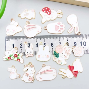Enamel bunny and paw charms for DIY jewelry making with ruler for size reference