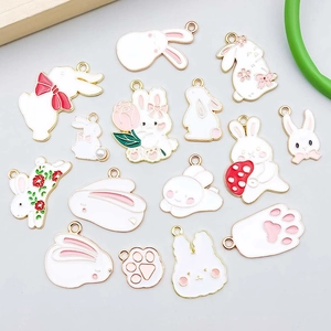 Macro detail of assorted enamel rabbit pendants and cat paw charms for DIY jewelry
