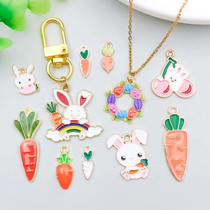 Vue à plat de breloques lapin et carotte en émail coloré avec porte-clés et colliers dorés