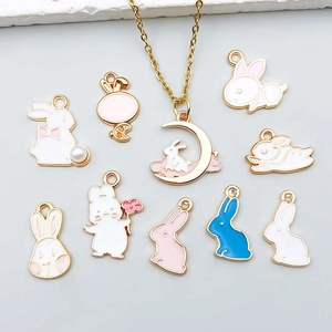 Detailed view of white and pink enamel bunny pendants for DIY jewelry crafting