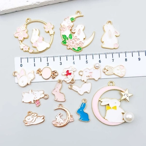 Set of 15 white and pink enamel rabbit pendants in moon and flower wreath designs