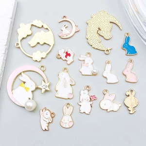 Macro detail of various cute enamel rabbit pendants for DIY jewelry with gold metal backing