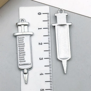 Detailed macro view of silver medical syringe pendants with centimeter ruler scale