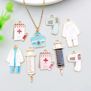 Flat lay of colorful enamel medical charms including doctor coats and thermometers for DIY