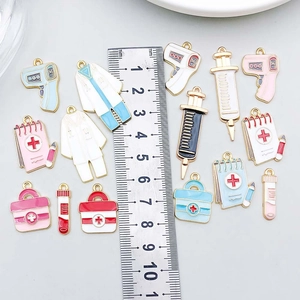 Assorted colorful enamel medical charms including syringe and first aid kit with scale
