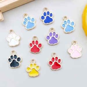 Flat lay of 10 colorful enamel cat paw pendants with golden alloy frames for DIY jewelry