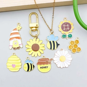 Detail van bijen- en zonnebloembedels met honingpotpendants voor DIY-sieraden maken