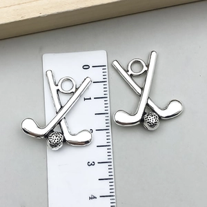 Macro detail of two golf club charms with integrated ring showing 2.6cm size measurement