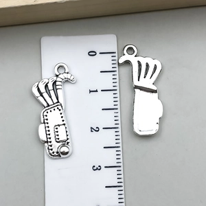 Detailed view of two golf bag metal pendants with ruler showing 2.8cm height dimension