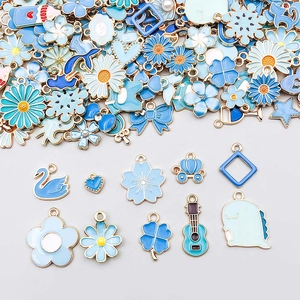 Gedetailleerde weergave van blauwe emaille bedeltjes in bloem- en hartvorm voor DIY-sieraden