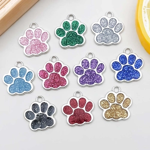 Macro detail of ten colorful glitter paw pendants with metal frames and hanging loops
