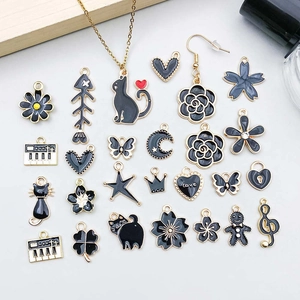 Flache Ansicht von Emaille-Anhängern in Schwarz und Gold für DIY-Schmuck mit Katzen und Blumen