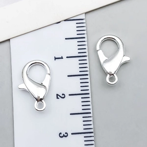 Close-up of 12mm silver alloy lobster clasp with ruler for precise size measurement