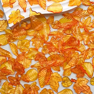 Macro detail of translucent orange acrylic maple leaf pendants for DIY jewelry crafting