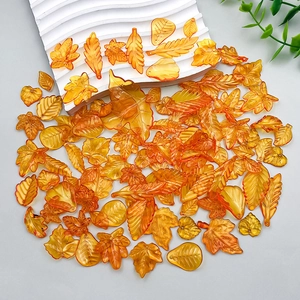 Macro shot of orange translucent acrylic leaf pendants with detailed vein textures for DIY