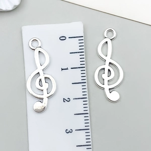 Silberner Violinschlüssel-Anhänger mit Lineal zur Anzeige der Höhe von etwa 2,5 cm