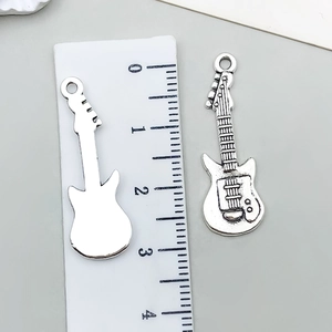 Makro-Detail des antiken silbernen E-Gitarren-Anhängers mit Vorder- und Rückseite