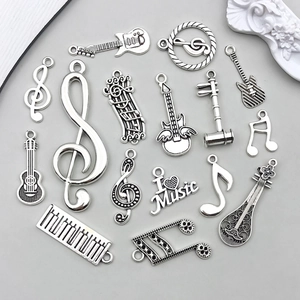 Nahaufnahme der Vintage-Silberanhänger mit Gitarren- und Notenmotiven für DIY-Schmucksets
