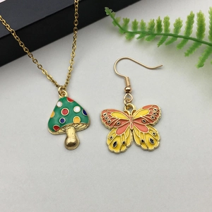 Detail of colorful enamel mushroom pendant necklace and butterfly earring set