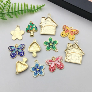 Detailed macro view of colorful enamel mushroom and butterfly alloy charms for DIY jewelry