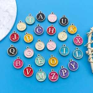 Macro shot of colorful enamel alphabet charms with gold plating for DIY jewelry making