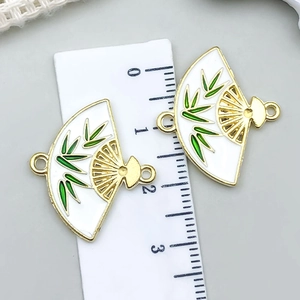 Detail van waaiervormige hangers met groen bamboe-email en een liniaal voor de meting