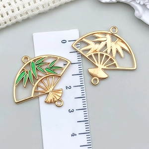Detail van kleurrijke bamboe waaierhangers met groen emaille en goudlaag voor DIY-sieraden