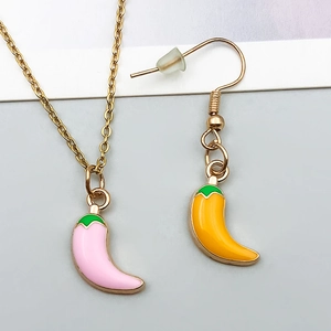 Detailed view of pink and yellow enamel chili pepper pendant necklace and earrings set