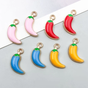Close-up of colorful enamel chili pendants in pink, red, blue and yellow with gold loops