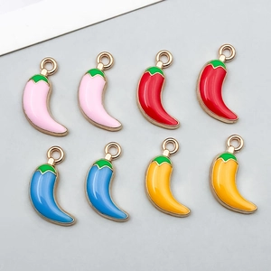 Macro detail of enamel chili pepper charms with gold-plated rings for DIY jewelry making