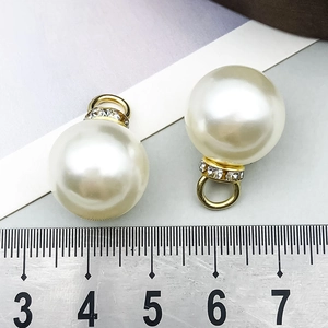 Detalle macro del colgante de perla de 16mm con aro de strass y enganche dorado para joyas
