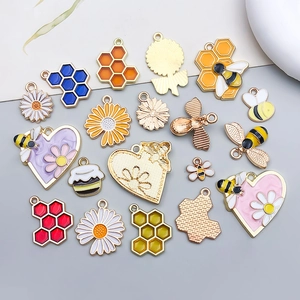 Flat lay of enamel bee and flower charms for DIY jewelry making accessories