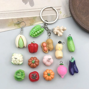 Flat lay of assorted mini resin vegetable charms including pumpkin and eggplant for DIY