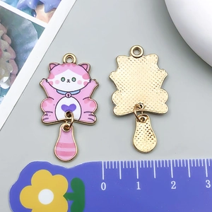 Detalle de dijes de gato de esmalte colorido con corazón rosa y vista dorada