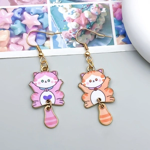 Detalle de dijes de gato en esmalte colorido con colas a rayas para hacer joyas