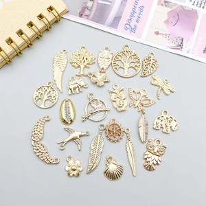 Detail of assorted gold alloy charms featuring tree, owl, and butterfly for DIY jewelry